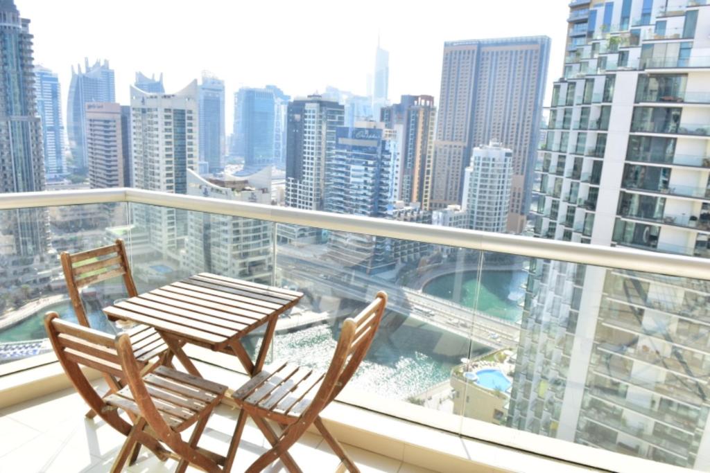 a table and chairs on a balcony with a view of a city at 1 BEDROOM APARTMENT in DUBAI MARINA & JBR in Dubai