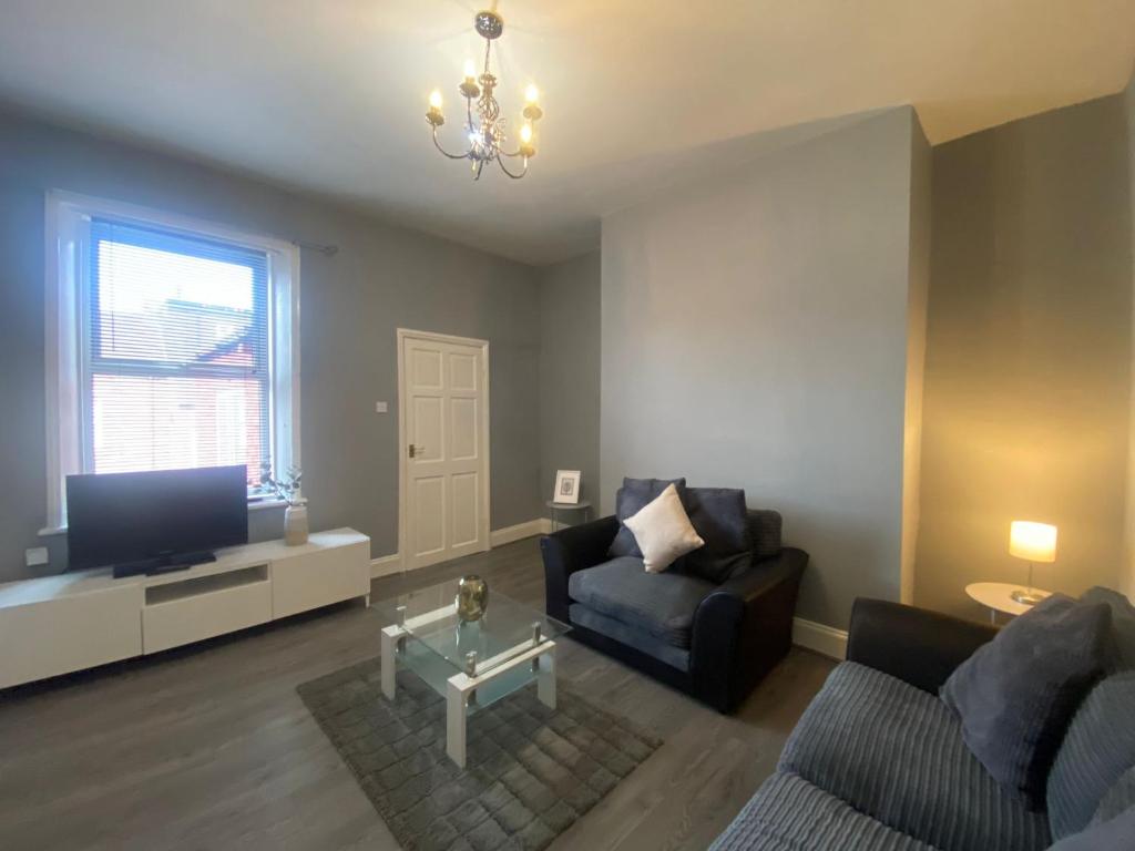 a living room with a couch and a tv at Alexander Apartments Tyneside in Gateshead