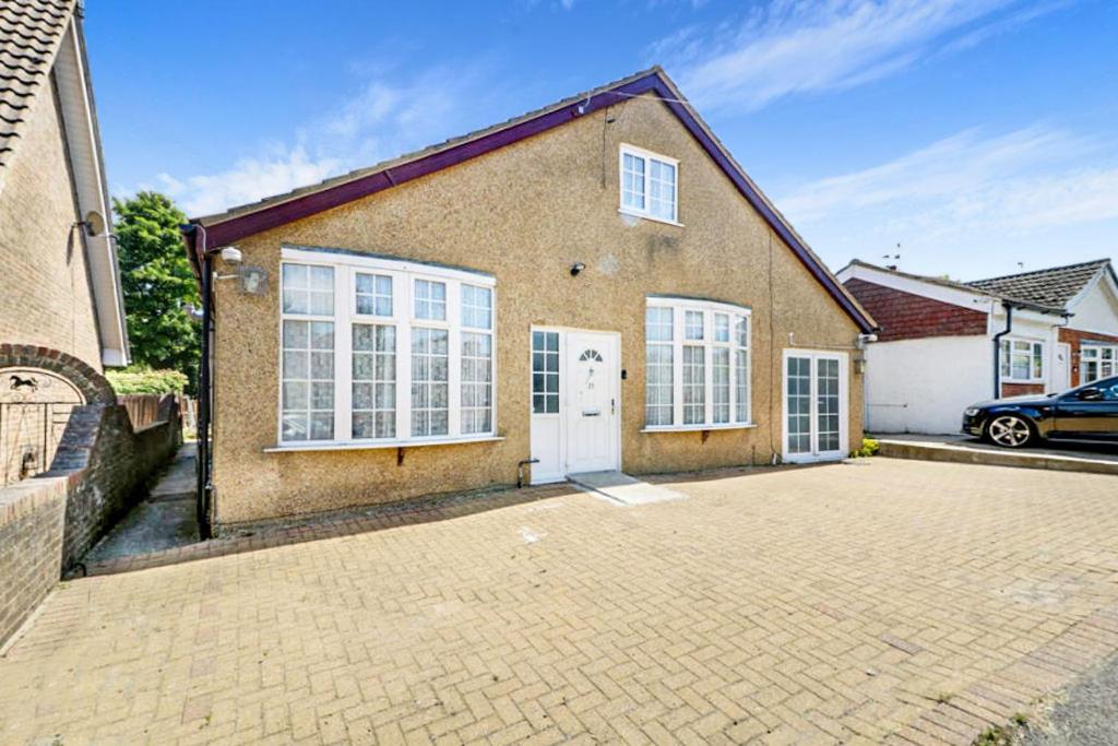 a brick house with a driveway in front of it at Detached bungalow with 7 bedrooms in Luton
