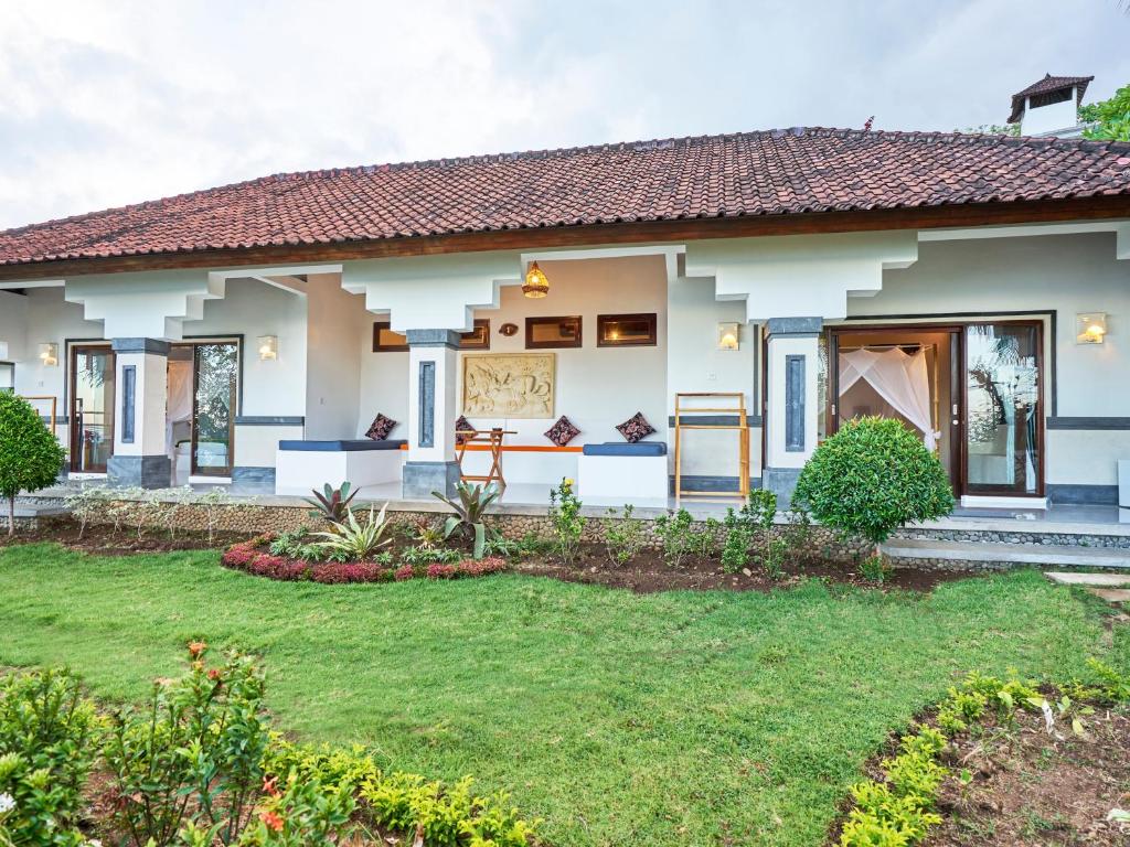 a home with a lawn in front of it at Anda Amed Villas & Spa in Amed