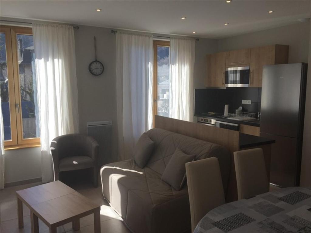 a living room with a couch and a kitchen at Appartement Mont-Dore, 3 pièces, 6 personnes - FR-1-415-67 in Le Mont-Dore