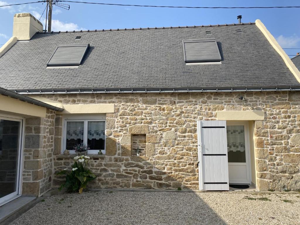 une maison en pierre avec une porte blanche et des fenêtres dans l'établissement Maison de Charme à Erdeven, Proche Plages et Sentiers, 3 Pièces, 4 Pers, Cour Privée - FR-1-397-38, à Erdeven