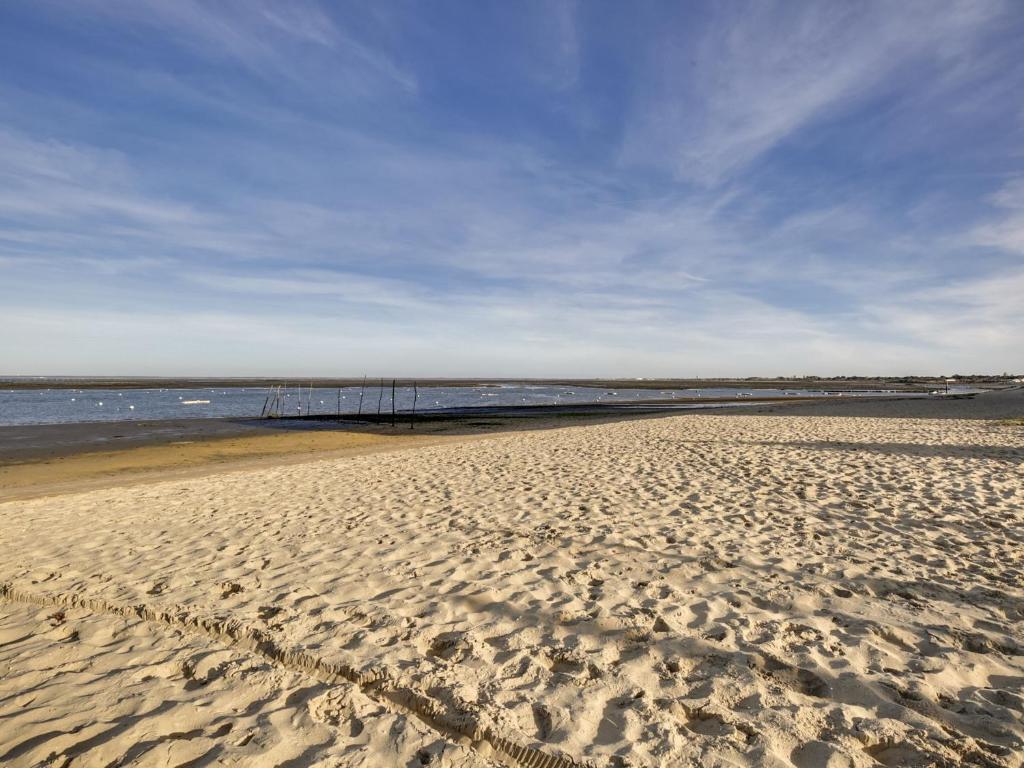 una playa de arena con un muelle en el agua en Appartement Arcachon, 2 pièces, 4 personnes - FR-1-474-19, en Arcachon