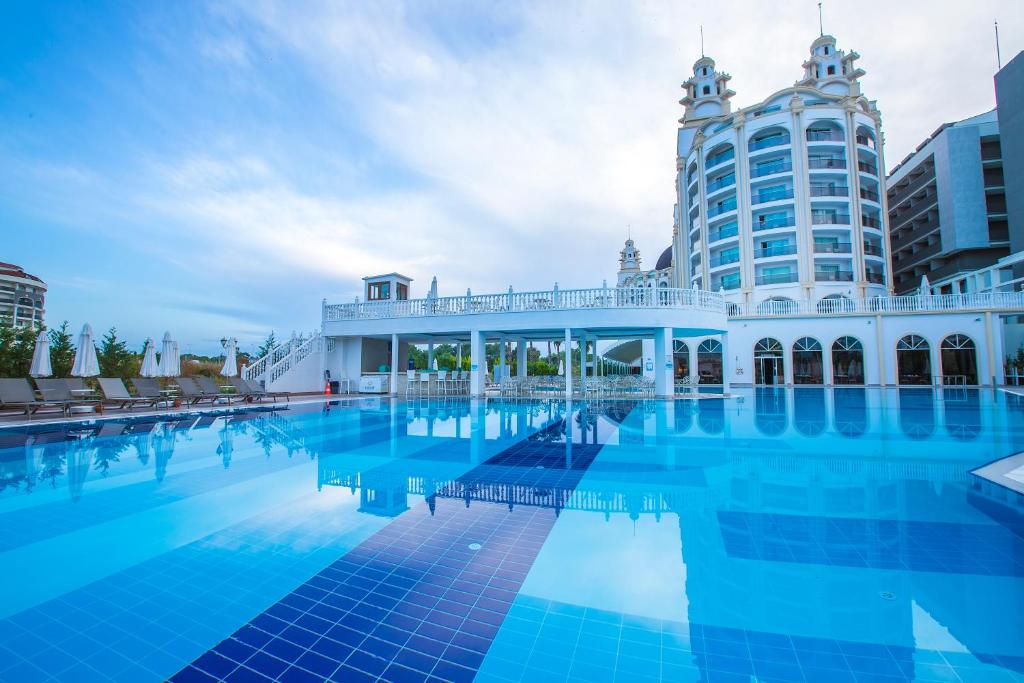 ein großer Pool mit einem Gebäude im Hintergrund in der Unterkunft J'adore Deluxe Hotel & Spa Ultra All Inclusive in Side