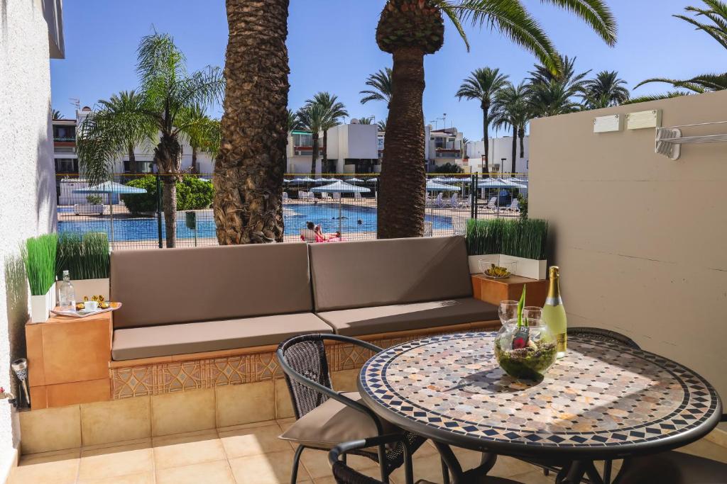 a patio with a table and a couch and a pool at Casa Lola in Costa Del Silencio