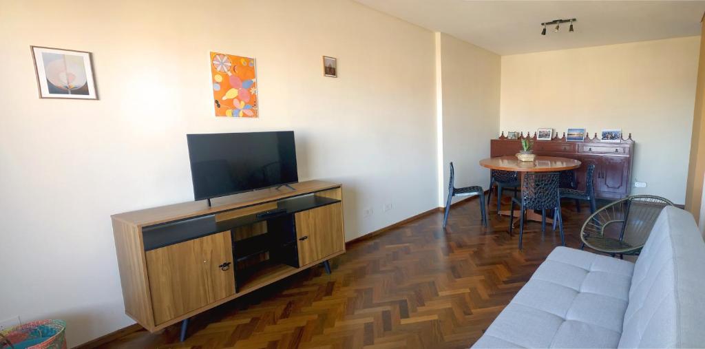 sala de estar con TV de pantalla plana y mesa en Departamento con gran vista en el casco histórico, en Asunción