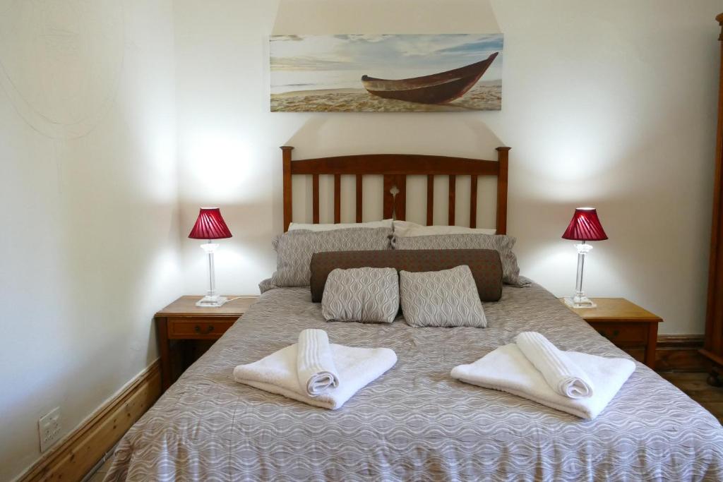 1 dormitorio con 1 cama con 2 toallas en Peerboom Guesthouse, en Fouriesburg