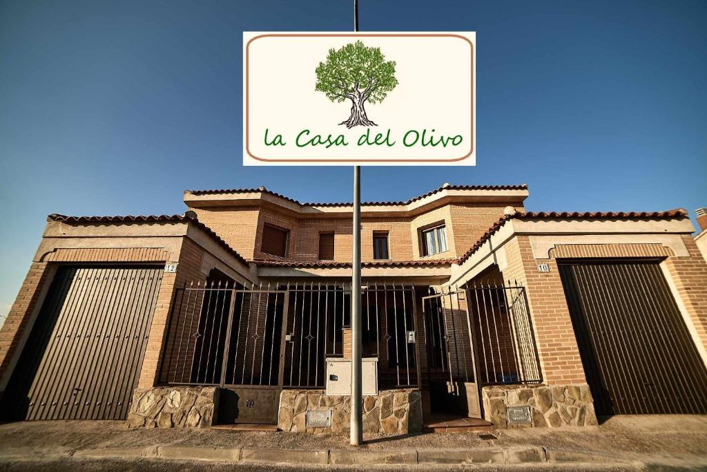 un panneau devant un bâtiment avec un arbre dans l'établissement La Casa del Olivo, à Navahermosa