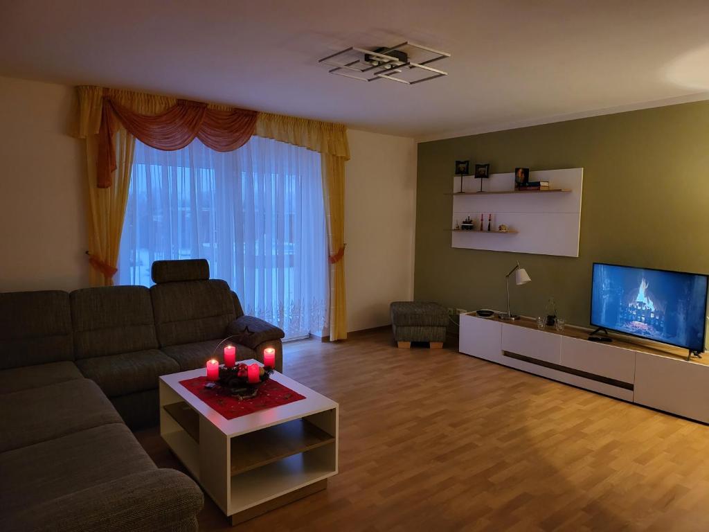 a living room with a couch and a tv at Haus Nutheblick - Komfort Appartement in Trebbin