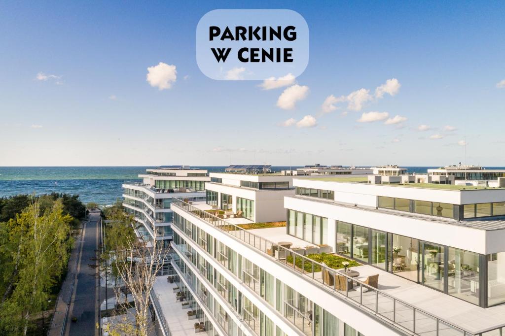 una rappresentazione di un edificio con l’oceano sullo sfondo di Dune Resort Mielno - C a Mielno