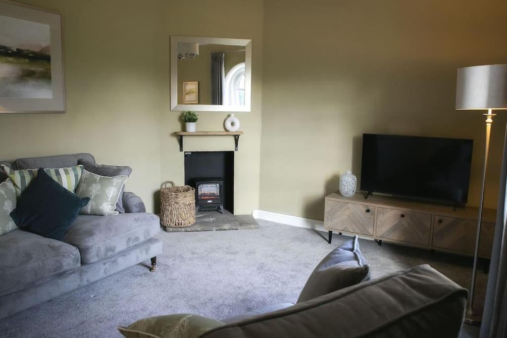 ein Wohnzimmer mit einem Sofa und einem TV in der Unterkunft Walshford Lodge in Cowthorpe