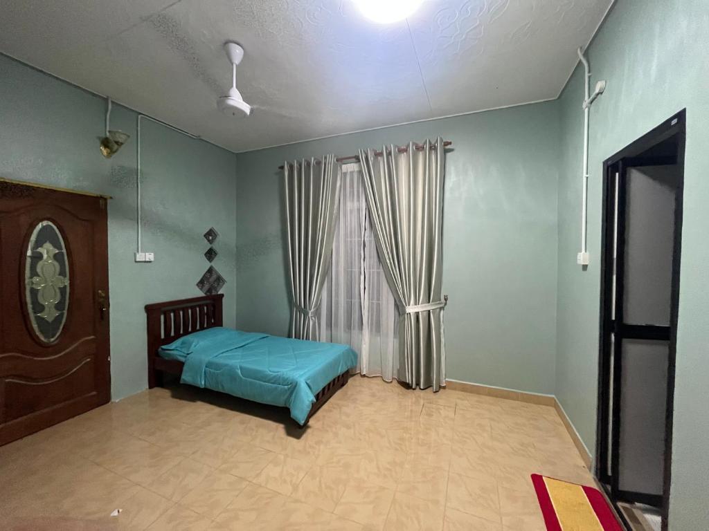 a bedroom with a bed and a window at AHZA MY HOMESTAY KEMAMAN in Cukai