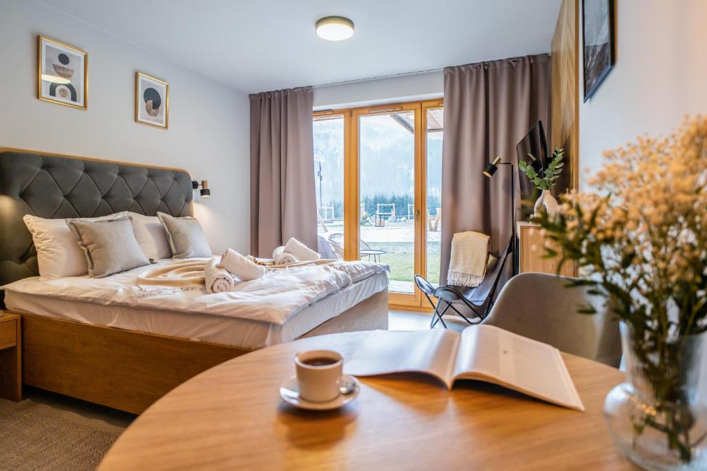 a bedroom with a bed and a table with a book at Apartament Wielka Turnia by Apart Concept Podhale in Kościelisko