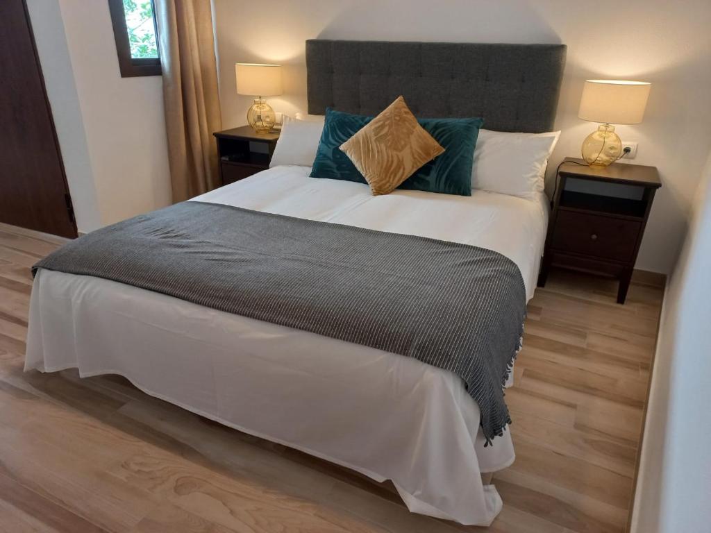 una camera da letto con un grande letto con due comodini di ALOJAMIENTO ÁGUILAS HOME zhr a Zahara de la Sierra