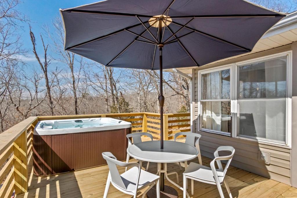 une terrasse avec une table, des chaises et un parasol dans l'établissement The Americana, à Bella Vista