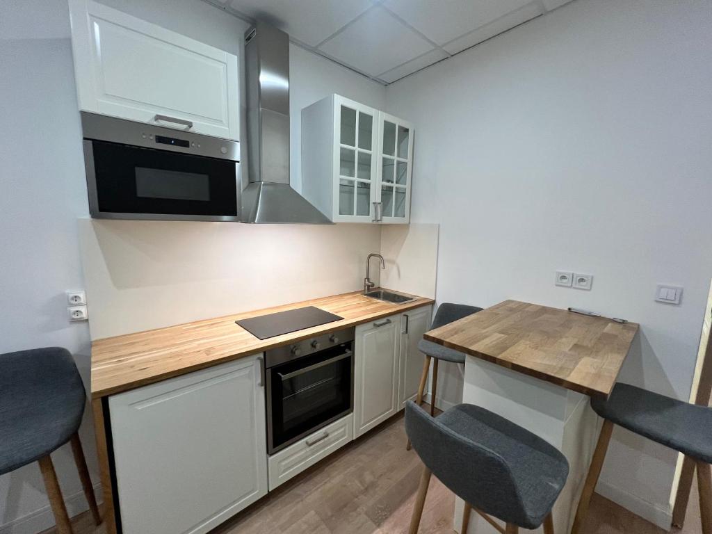małą kuchnię z drewnianym stołem i krzesłami w obiekcie Studio Climatisé Centre Ville #9 w mieście Tulon
