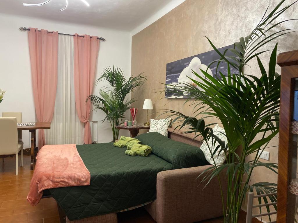 Un dormitorio con una cama verde y plantas. en Appartamento Benaco a Milano - Fondazione Prada en Milán