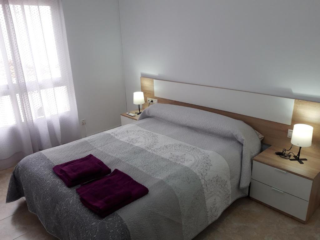 Un dormitorio con una cama con almohadas moradas. en VFT LA PAZ II, en Baeza