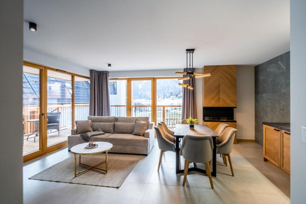 een woonkamer met een bank en een tafel bij Apartament Tarasowa Polana by Apart Concept Podhale in Kościelisko