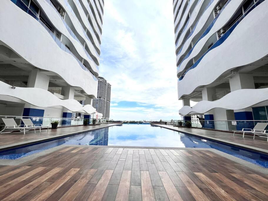 a swimming pool in the middle of two tall buildings at Concept Suite 05 @ The Wave Residence in Tranquerah