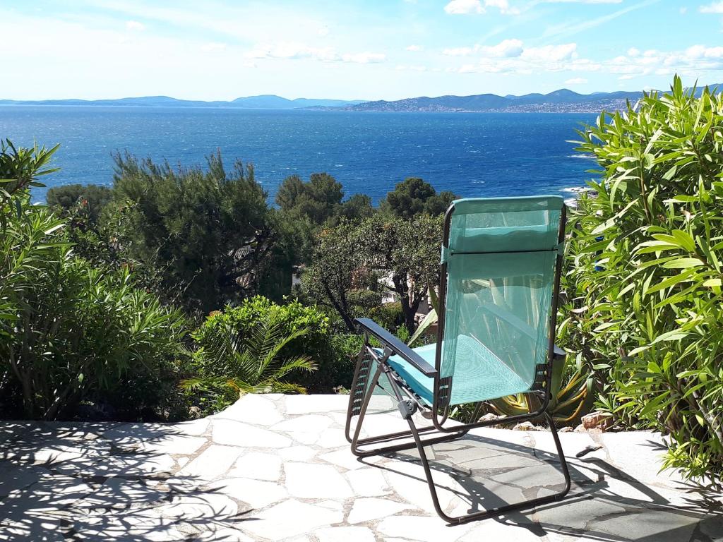 une chaise verte assise sur une terrasse donnant sur l'océan dans l'établissement Duplex, vue panoramique sur la Méditerranée, piscine, garage, à Saint-Raphaël