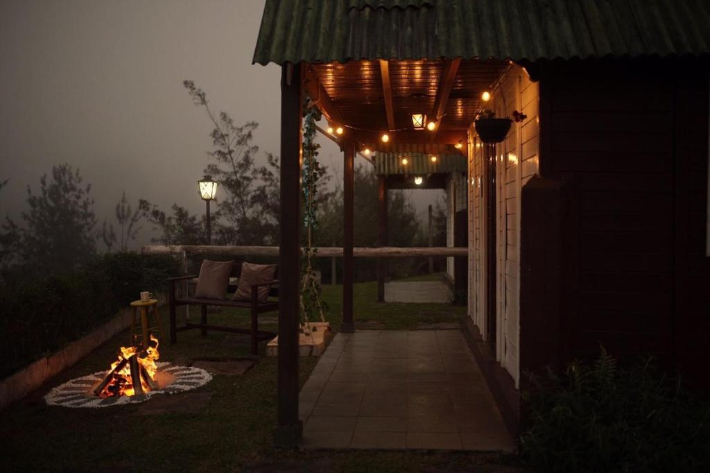 una pérgola con luces en un patio por la noche en Cabanas Capivari Lodge en Campos do Jordão
