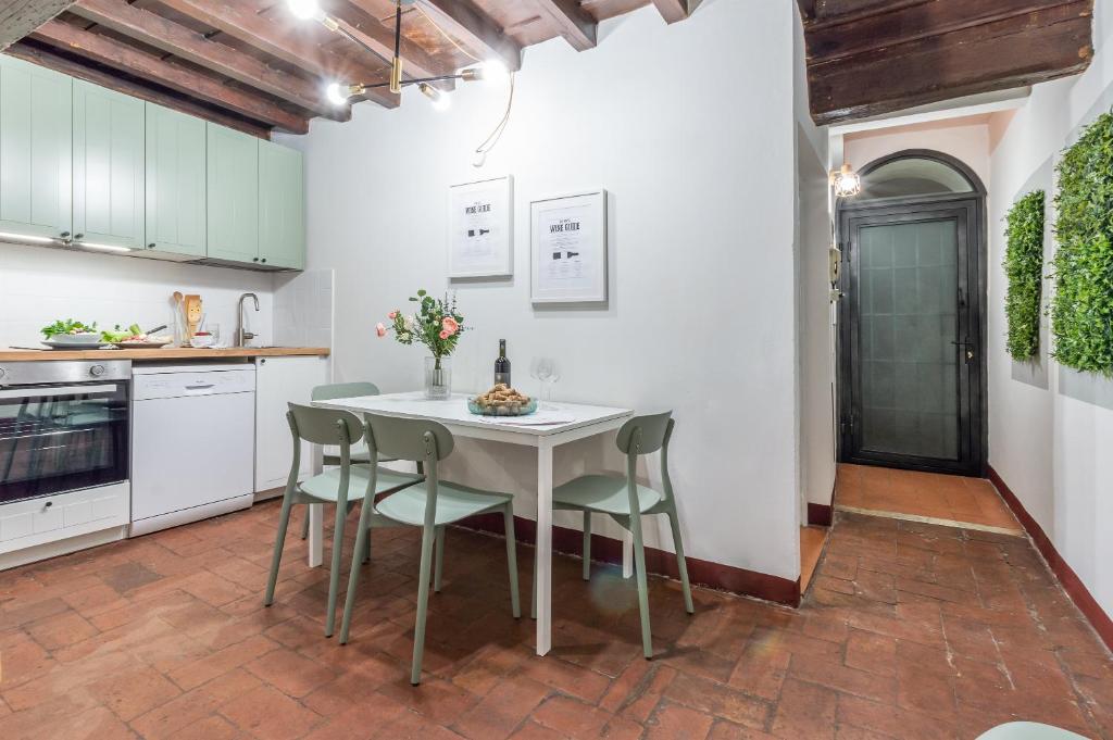 una cucina con tavolo e sedie bianchi di Wine Apartments Florence Ciliegiolo a Firenze