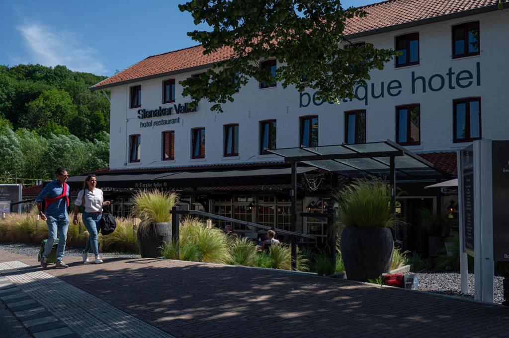 two people walking in front of a hotel at Boutique Hotel Slenaker Vallei - Buitengewoongenieten in Slenaken