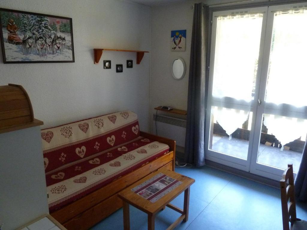 a living room with a couch and a sliding glass door at Studio Valloire, 1 pièce, 4 personnes - FR-1-263-14 in Valloire