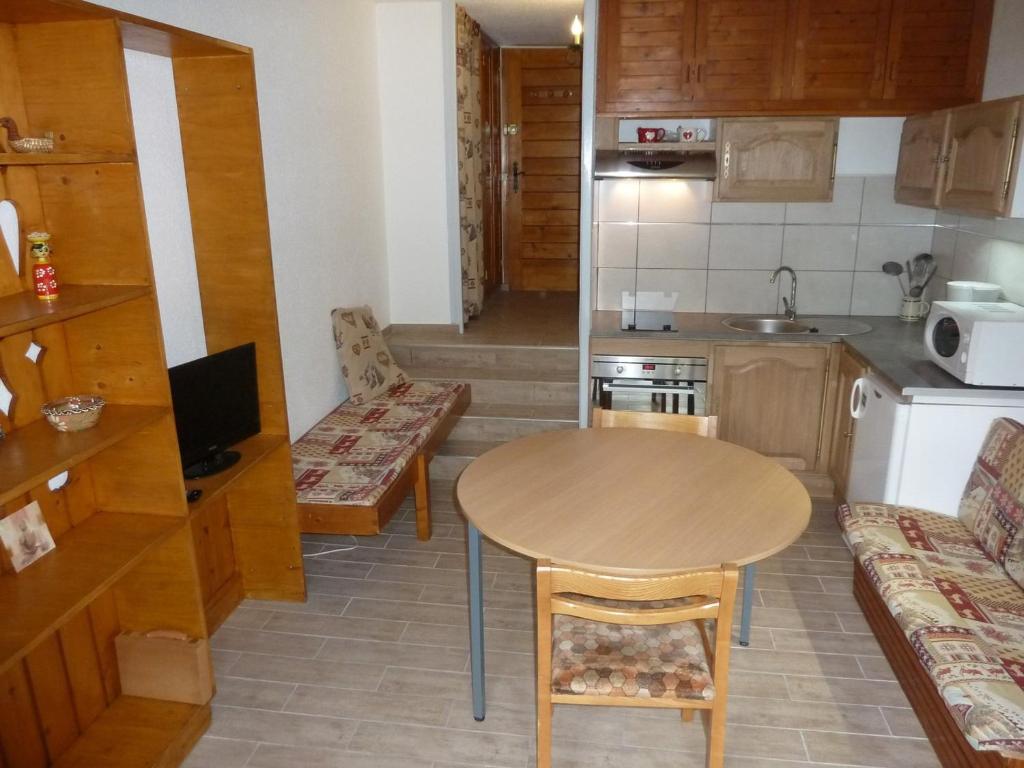 a small kitchen with a wooden table and a table and chairs at Studio Valloire, 1 pièce, 2 personnes - FR-1-263-29 in Valloire