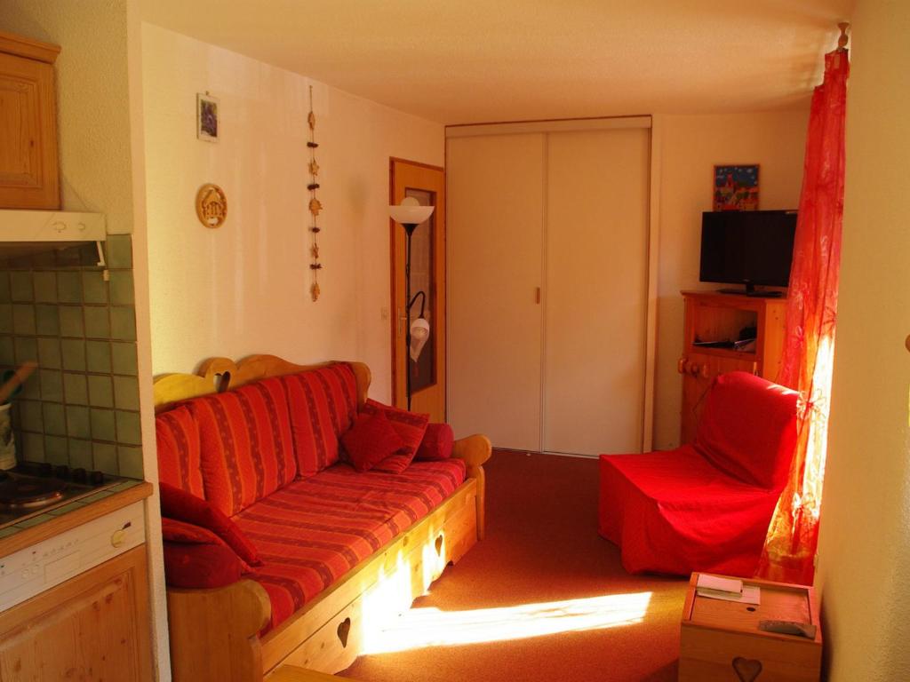 a living room with a red couch and a chair at Studio Valloire, 1 pièce, 3 personnes - FR-1-263-54 in Valloire