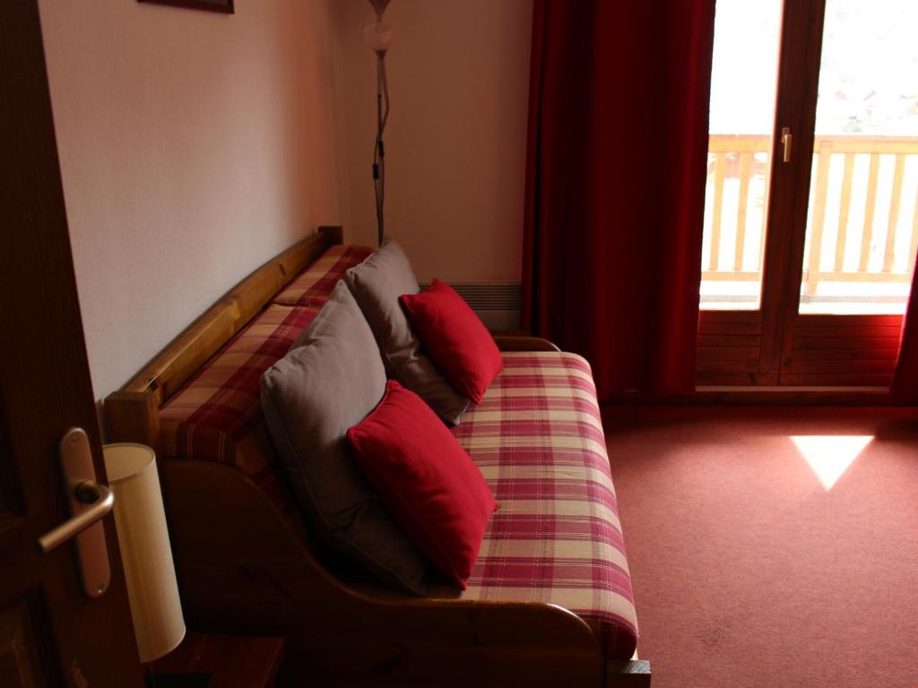 a couch with red pillows on it in a room at Appartement Valloire, 2 pièces, 4 personnes - FR-1-263-124 in Valloire