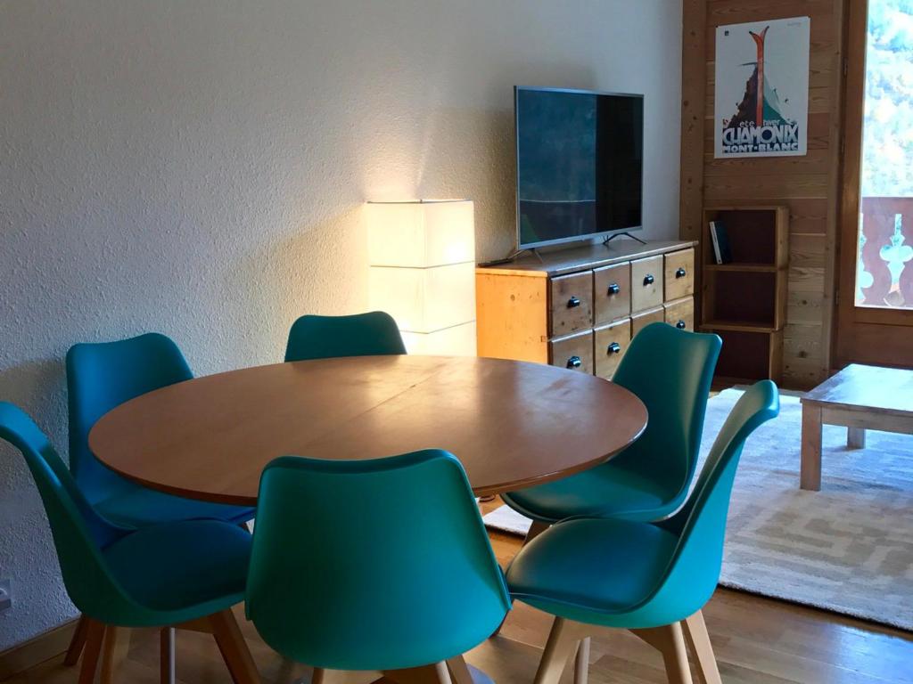 a dining room with a wooden table and green chairs at Appartement Valloire, 2 pièces, 6 personnes - FR-1-263-408 in Valloire