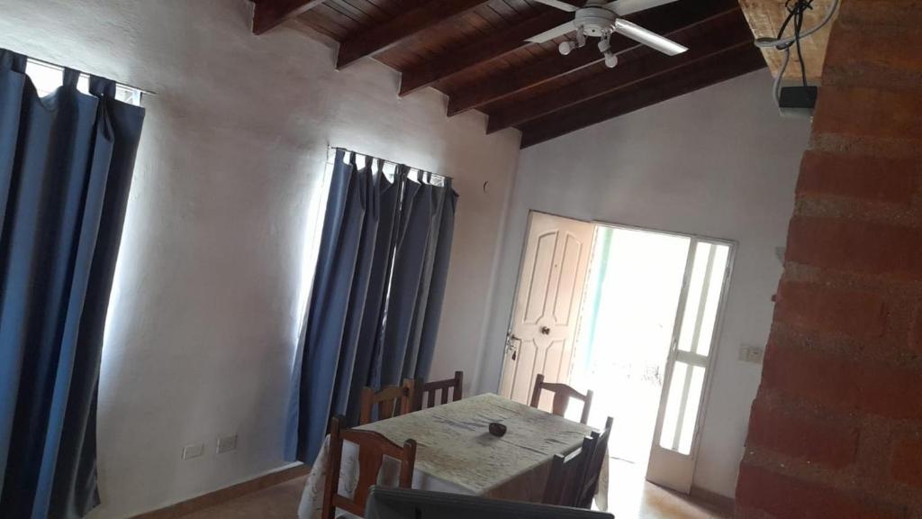 ein Esszimmer mit einem Tisch und blauen Vorhängen in der Unterkunft Cabañas Comodoro in Mina Clavero