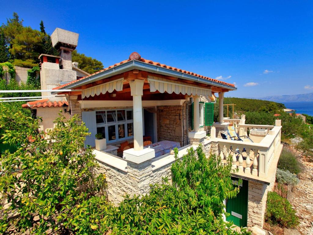 a small house with a balcony on a hill at Stone House Horizont in Vela Luka