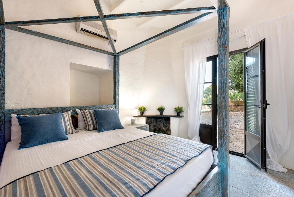 a bedroom with a canopy bed with blue pillows at Villa Nice Mallorca in Palma de Mallorca
