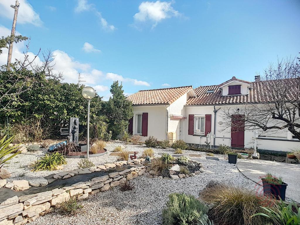 une maison avec un chemin en pierre en face d'une cour dans l'établissement Charmant F2 avec terrasse près du centre et des thermes, animaux acceptés, options de services disponibles - FR-1-451-31, à Lamalou-les-Bains