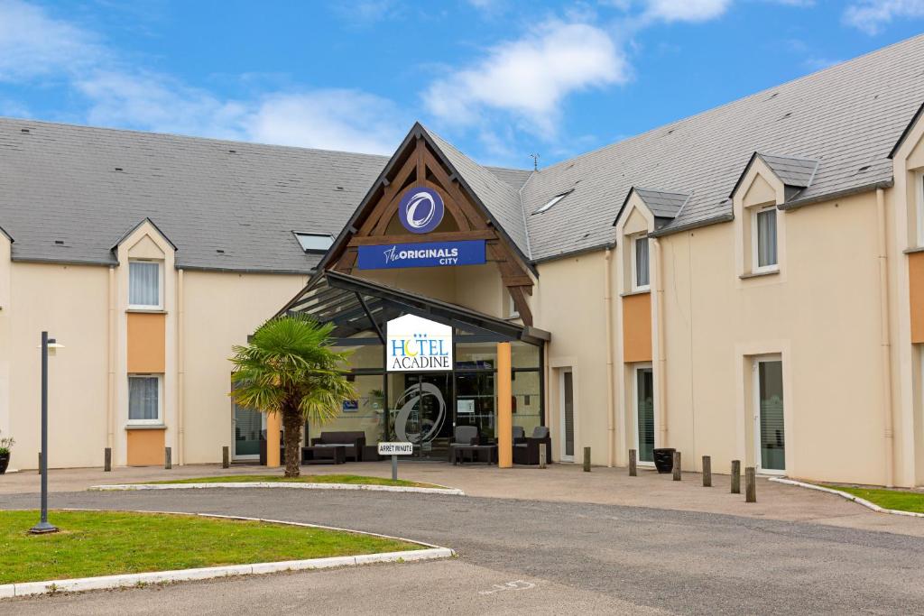 a hotel with a sign on the front of it at The Originals City, Hôtel Acadine, Le Neubourg (Inter-Hotel) in Le Neubourg