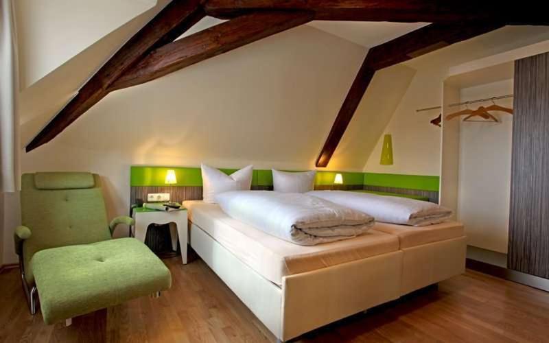 een slaapkamer met een groot bed en een muur met groene accenten bij Goldener Adler in Sulzheim