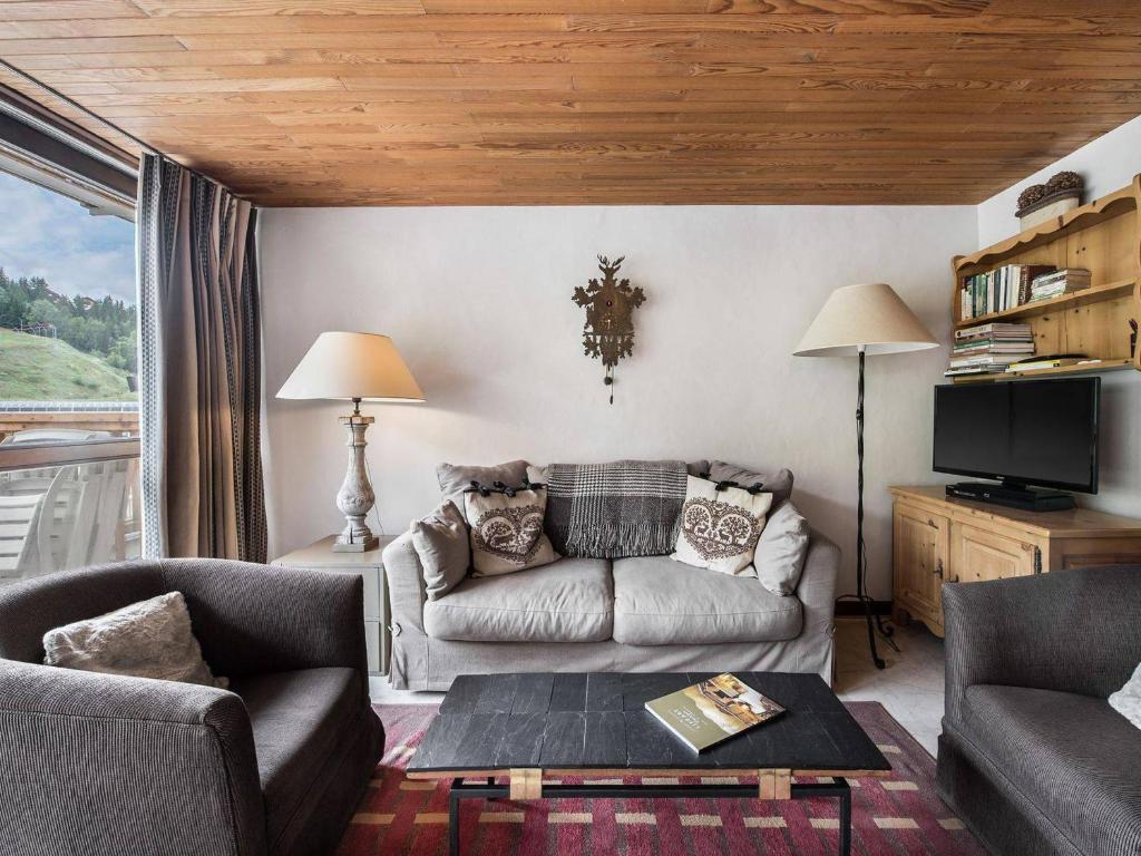 ein Wohnzimmer mit einem Sofa und einem TV in der Unterkunft Appartement Courchevel 1550, 3 pièces, 6 personnes - FR-1-562-4 in Courchevel