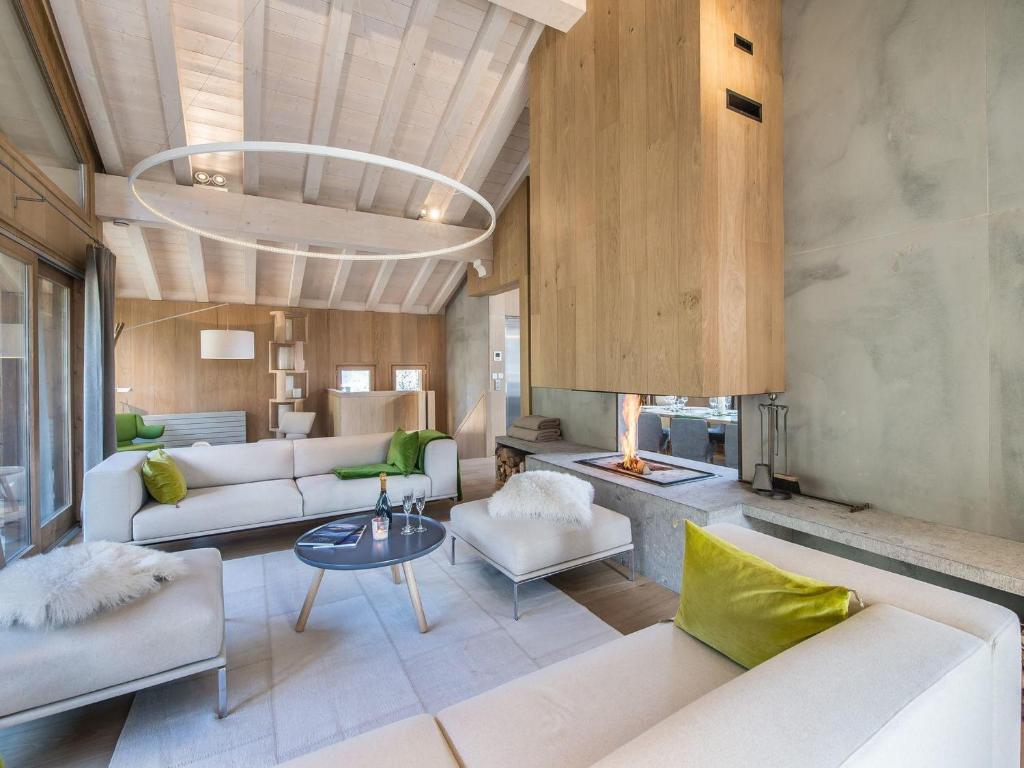 Una sala de estar con muebles blancos y chimenea. en Chalet de luxe avec jacuzzi, hammam et salle de cinéma à Courchevel - FR-1-562-43, en Courchevel