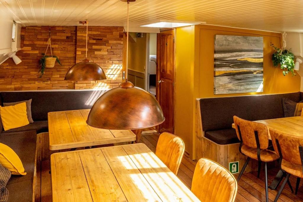 a dining room with wooden tables and chairs at Boutique style ship 10 double cabins in Monnickendam