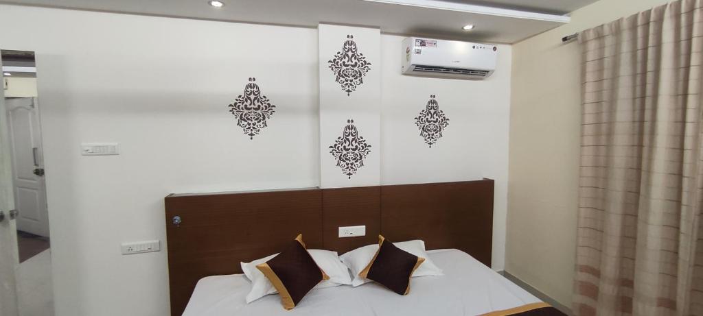 a bedroom with a bed with white sheets and brown pillows at Happy Vibes Stay 2Bhk flat in Vānivilāsa Puram
