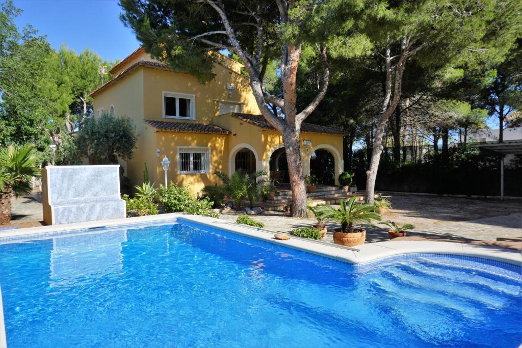 a swimming pool in front of a house at RINCONCILLO in Denia