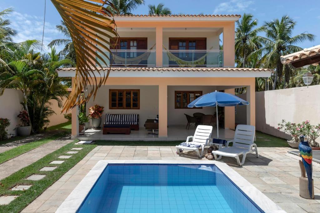 a villa with a swimming pool and a house at Casa de Praia Maragogi in Maragogi