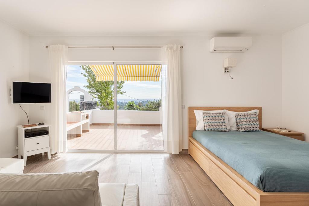 1 dormitorio con cama y vistas a un balcón en ALTIDO Cosy studio wtih parking and garden, 