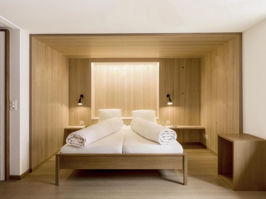 a room with a bed with two pillows on it at Hotel Alpina in Vals