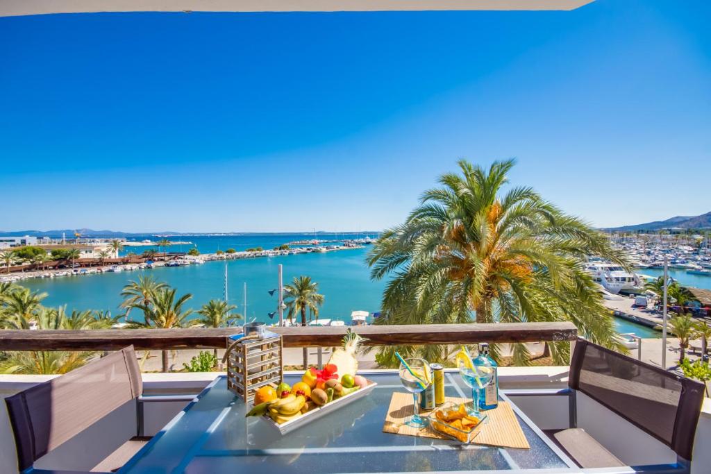 een tafel met fruit op een balkon met uitzicht op de oceaan bij Ideal Property Mallorca - Enjoy in Port d'Alcudia