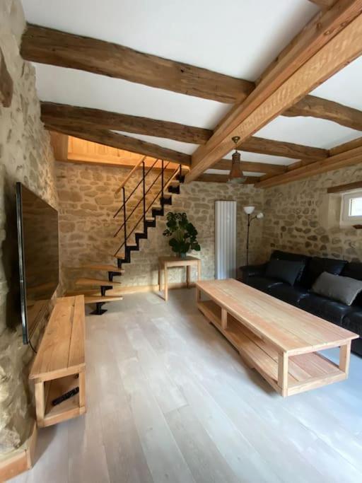 a living room with a couch and a staircase at Gîte : La vieille bâtisse. in La Baume-Cornillane