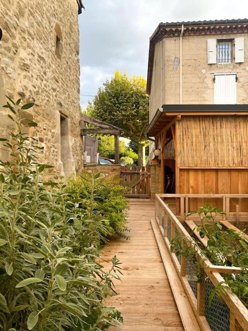 a wooden walkway in front of a building at Gîte : La vieille bâtisse. in La Baume-Cornillane